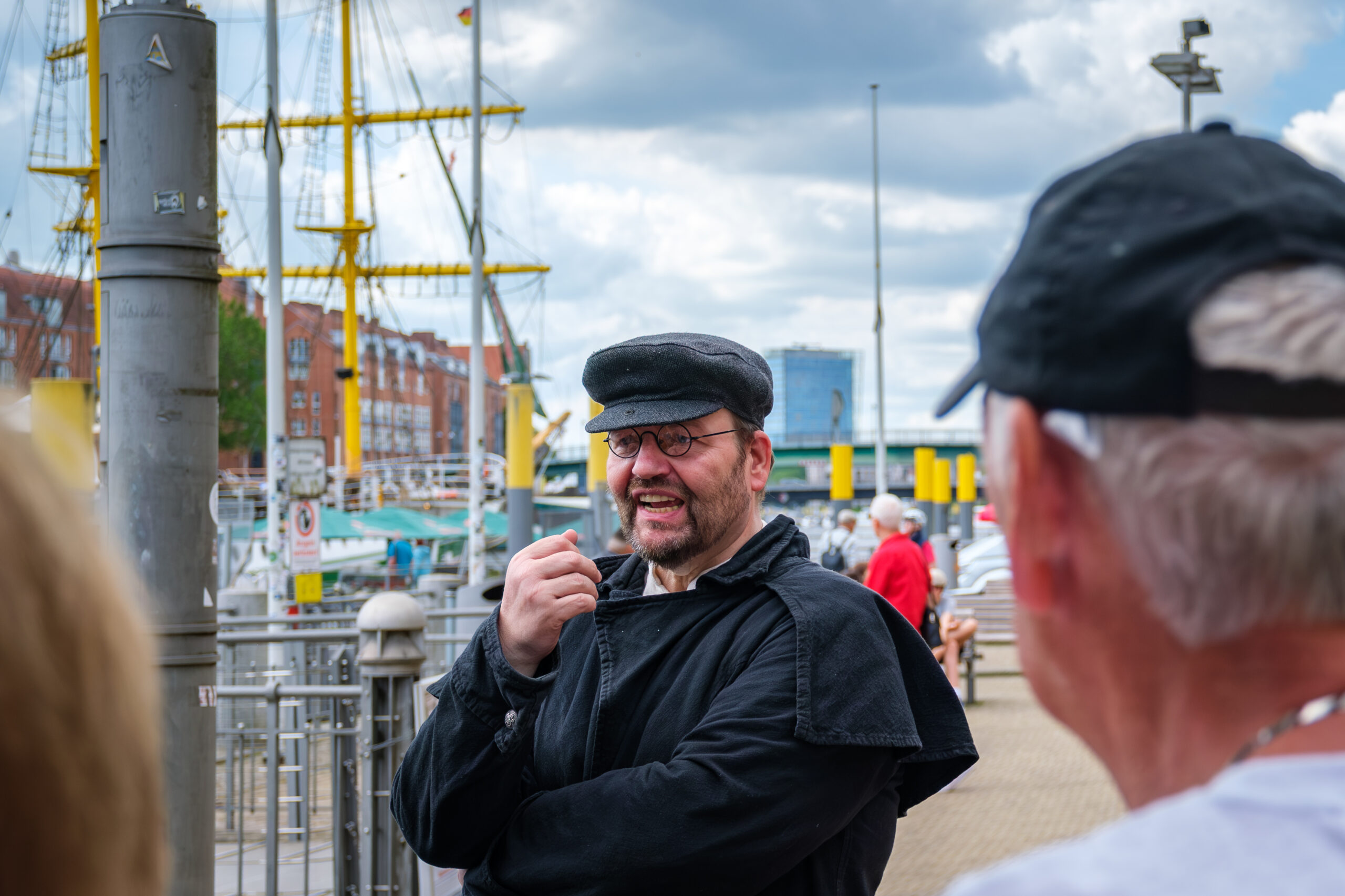 Stadtführung „Bremen ganz anders“ mit Darsteller am Martinianleger an der Weser vor historischen Segelschiffen