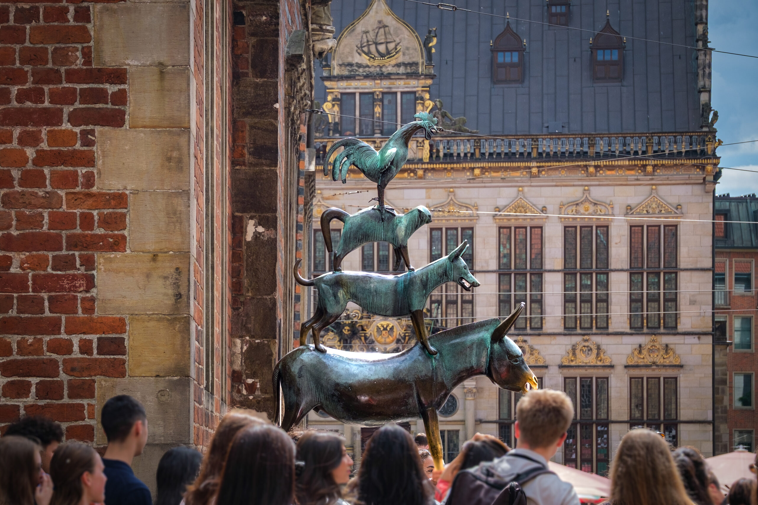 Teilnehmende der StattReisen Stadtführung „Bremen ganz anders“ mit Bremer Stadtmusikanten und Schütting